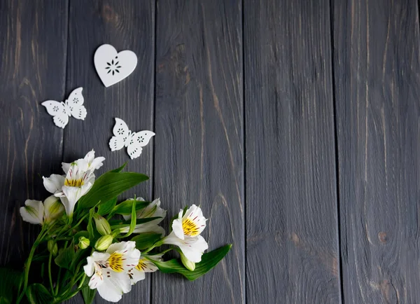 Hintergrund für Textbanner auf dunklem Holzgrund mit weißen Blumen und Schmetterlingen. leer, Rahmen für Text. Grußkarten-Design mit Blumen. aalstroemeria auf Holzgrund. Blick von oben — Stockfoto