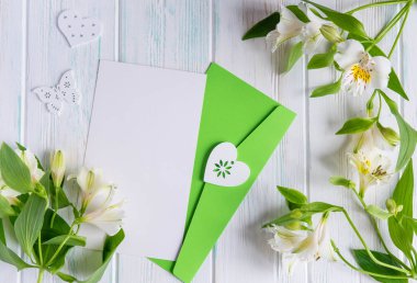 Boş kağıt, posta zarf üzerinde beyaz bir ahşap arka plan beyaz renk ve kelebekler doğal çiçekler ile alay. Boş, çerçeve metin için. Tebrik kartı tasarımı ile çiçekler. Aalstroemeria ahşap b