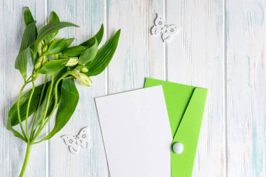 Boş kağıt, posta zarf üzerinde koyu ahşap arka plan beyaz renk ve kelebekler doğal çiçekler ile alay. Boş, çerçeve metin için. Tebrik kartı tasarımı ile çiçekler. Aalstroemeria tarihinde ahşap ba