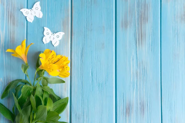 Mock up blank paper, mail envelope on a dark wooden background with natural flowers of white color and butterflies. Blank, frame for text. Greeting card design with flowers. Aalstroemeria on wooden ba