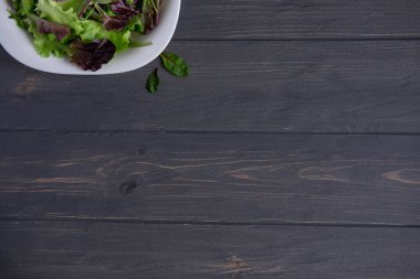 Beyaz ahşap zemin üzerinde marul ile plaka. Yeşil salata. Organik gıda. Vegans için yiyecek. Doğal gıda ile bir banner tasarımı. Kilo vermek için salata. Düz yatıyordu, en iyi görünümü.