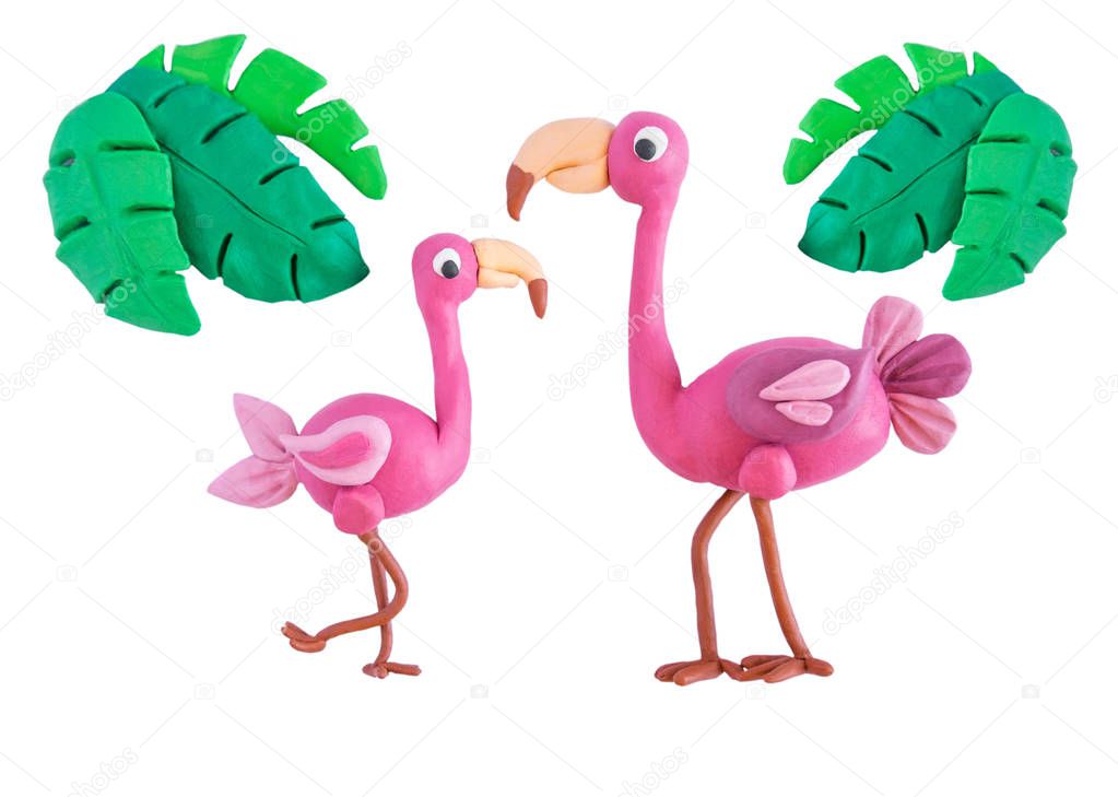 Pink flamingo with palm leaves made of plasticine isolated on white background. Crafts from platinum. Children crafts. Plasticine bird flamingo