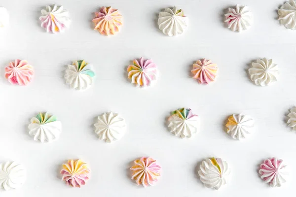 Multi-colored meringue on a white background. Sweets on the photo. Pattern with meringue on a white background. Sweet holidays — Stock Photo, Image