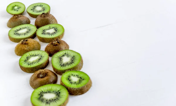 Foto av kiwi skivad på vit trä bakgrund med copispeys. Tropiska frukter, rätt kost och diet — Stockfoto