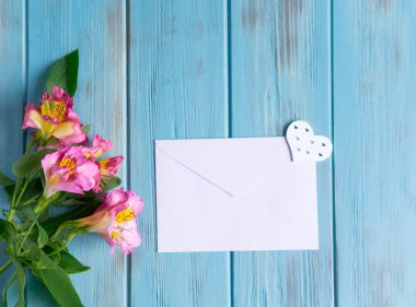 Beyaz renk doğal çiçekler ile koyu ahşap arka plan üzerinde boş kağıt ve zarf kadar mock. Boş, metin çerçevesi. Çiçekler ile tebrik kartı tasarımı. Aalstroemeria arka plan. Düz yatıyordu, üst görünüm.