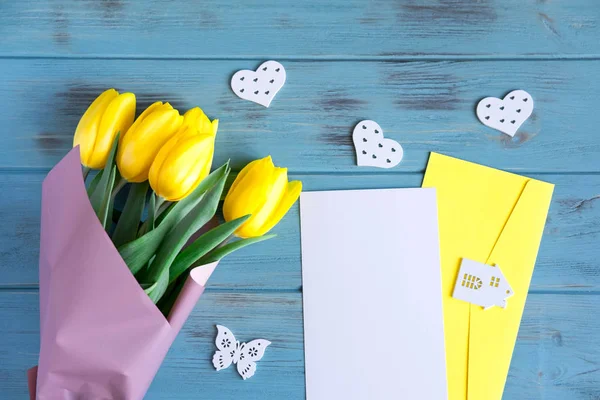 Жовті тюльпани на синьому дерев'яному фоні. Дизайн вітальних листівок з тюльпанами. Банер для дизайну з натуральними жовтими квітами та копіюванням простору. Плоский прошарок, вид зверху . — стокове фото