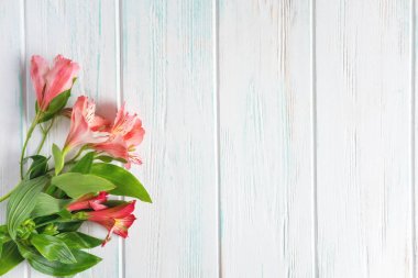 Çiçeklerle tebrik kartı için çerçeve. Ahşap bir arka plan üzerinde doğal alstroemeria çiçekleri ile Afiş. Alstroemeria çiçekleri ile metin için Çerçeve. Düz döşeme, üst görünüm.