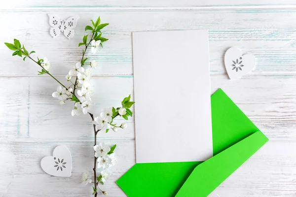 Disposición para tarjeta de felicitación con flores. Fingir en blanco, plantilla, marco para una entrada de blog. Marco para texto con flores de cerezo, carta y sobre de correo. Piso tendido, vista superior . — Foto de Stock