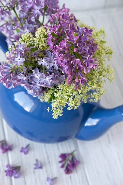 Lila egy teáskanna kék színű, amelynek helye a felirat egy fából készült háttérrel. Lilac virágok — Stock Fotó