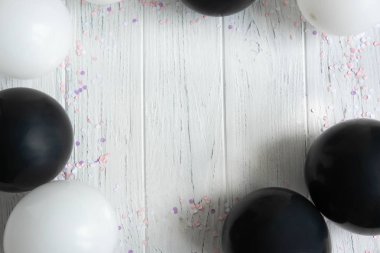 Tebrik kartı metni için tasarım çerçevesi, balonlarla afiş. Balonlar beyaz ve siyah açık ahşap arka plan üzerinde. Doğum günü arka planı