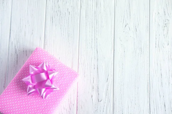 Fondo blanco con una caja de regalo rosa. Presenta cajas sobre un fondo de madera. Marco para la tarjeta de felicitación. Certificado de regalo, diseño de folleto con descuento, regalo — Foto de Stock