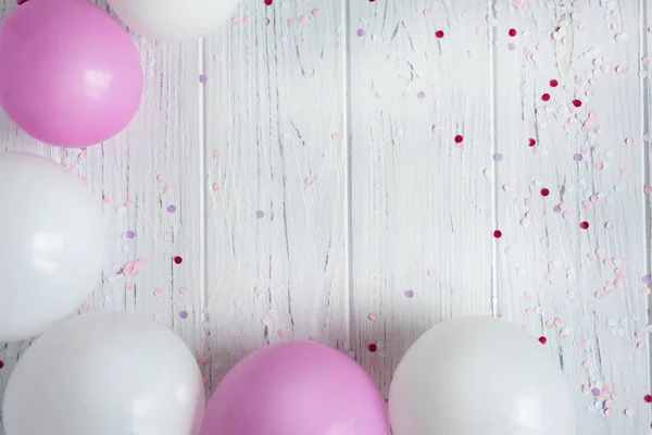 Marco de diseño para el texto de la tarjeta de felicitación, banner con globos. Globos blancos y rosados sobre un fondo de madera claro —  Fotos de Stock