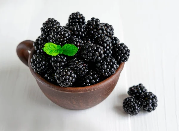 Brombeeren in einer Keramiktasse auf hellem Hintergrund. Foto auf weißem Hintergrund für Designer. gesunde Beeren — Stockfoto