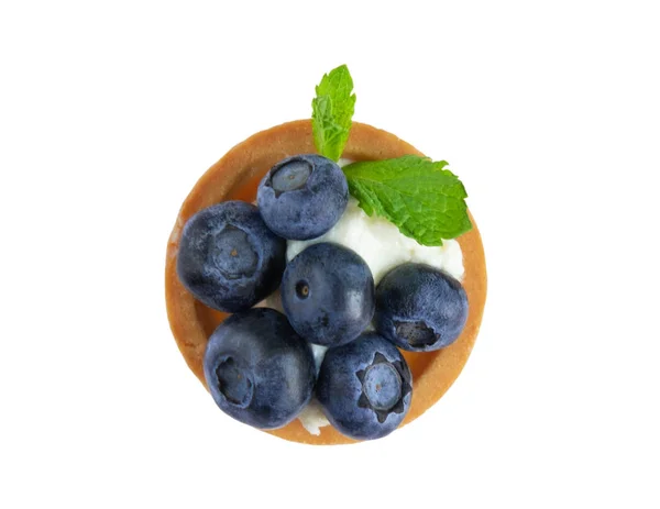 Makrofoto von Törtchen mit Heidelbeeren, Blaubeeren und Minzblättern isoliert auf weißem Hintergrund. Kuchen mit Käsecreme und frischen Blaubeeren. Blick von oben — Stockfoto