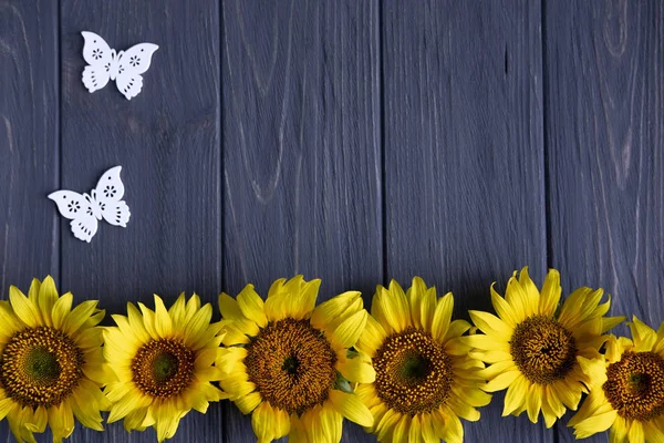 Projekt karty okolicznościowe z słoneczniki na szarym tle drewnianym. Ramka na tekst z kwiatami słonecznika. Słoneczniki zdjęcie z miejscem na copywriting. Widok z góry — Zdjęcie stockowe