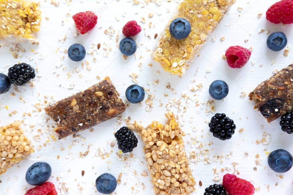 Pattern foto with cereal bars and blueberries, blackberries and raspberries with oatmeal. Healthy snacks and breakfasts