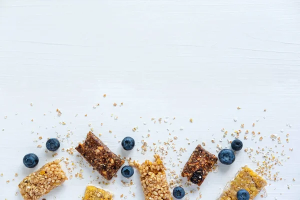 Banner met blauwe bessen en energierepen op een witte houten achtergrond. Blueberry granola en bessen met een plaats voor inschrijving en gebruik in reclame, blog post. Gewichtsverlies en goede voeding — Stockfoto