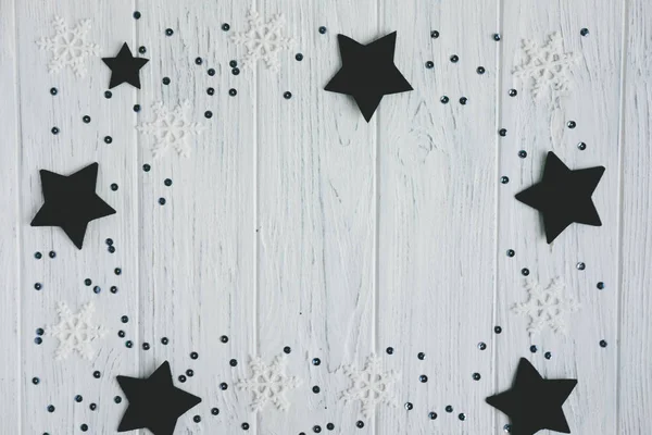 单色背景，浅木背景上有雪花和星星。文本问候语和新年横幅的框架。从上面查看 — 图库照片