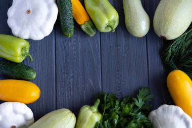 Taze sebze kabak, salatalık, lahana, yeşil biber, maydanoz, dereotu gri ahşap arka plan üzerinde Afiş. Taze sebzelerden yapılmış metin çerçevesi.
