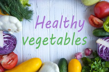 Taze sebze lahana, kabak, kabak, domates, salatalık, dereotu, maydanoz ile hafif ahşap arka plan üzerinde yazıt yararlı sebzeler