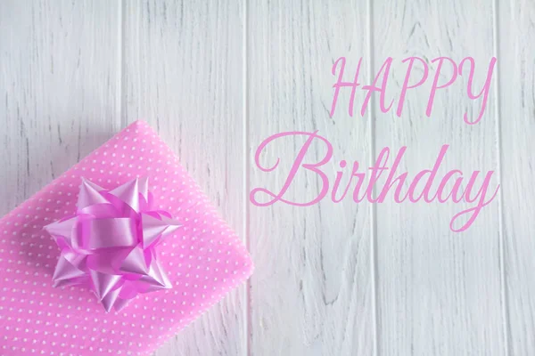 Wenskaart met de inscriptie Happy Birthday. Felicitatie groet aan het meisje, moeder met geschenk op een houten achtergrond — Stockfoto