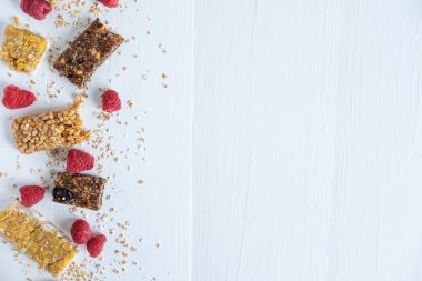 Hafif ahşap arka plan üzerinde tahıl ve taze ahududu çilek ile Barlar. Sağlıklı kahvaltı, doğru beslenme, vejetaryenler ve kilo kaybı için vitamin menüsü. Granola Barlar, Lif ve Çilek