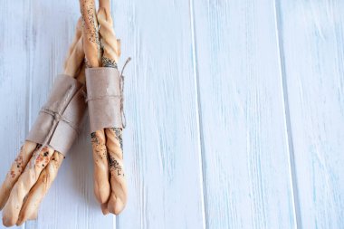 Hafif ahşap bir arka plan üzerinde ekmek çubukları yakın çekim. Grissini'nin bir yazıt yeri var. Yemekler için menü çerçevesi