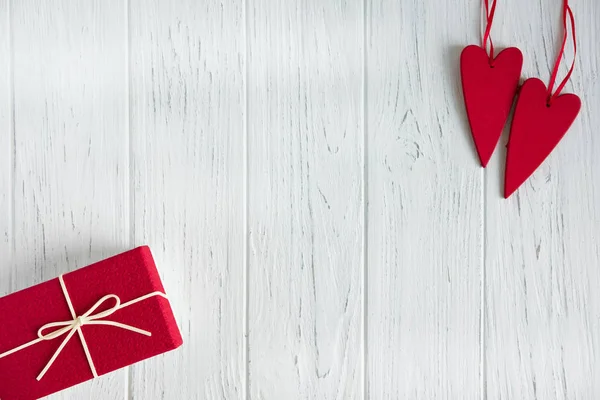 Marco para la tarjeta de felicitación de texto para el día de San Valentín. Caja con un regalo y corazones rojos sobre un fondo de madera claro. Marco para los amantes. Fondo del día de San Valentín — Foto de Stock