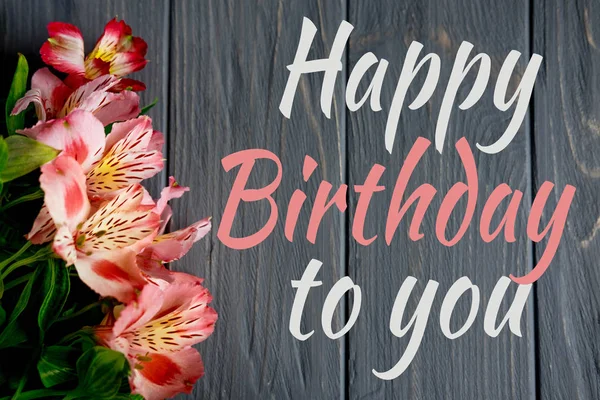Üdvözlőkártya a felirat boldog születésnapot. Köszöntő üdvözlés, hogy a lány, anya virágokkal és egy ajándék a fából készült háttérrel. Alstroemeria virágok — Stock Fotó