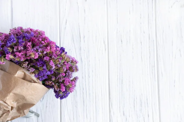 Bouquet of dried wildflowers on a light wooden background. Birthday Greeting Banner. Frame for text with wildflowers. View from above