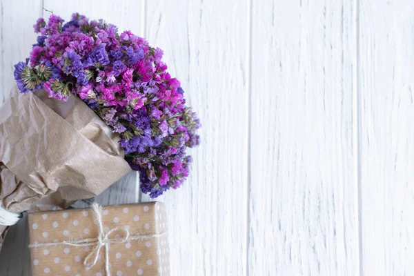 Ramo de flores silvestres secas con caja de regalo sobre un fondo de madera. Diseño de tarjeta de felicitación con flores . —  Fotos de Stock