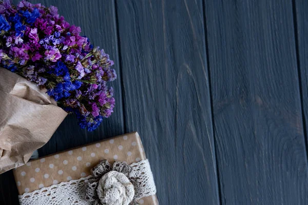 Ramo de flores silvestres secas con caja de regalo sobre un fondo de madera. Diseño de tarjeta de felicitación con flores . —  Fotos de Stock