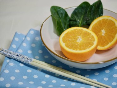 Portakal ve bir seramik kase ıspanak