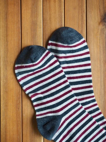 Wood board background with striped socks, autumn socks