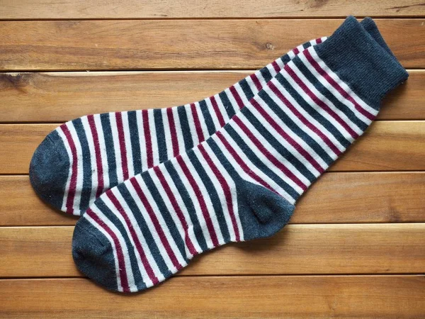 Wood board background with striped socks, autumn socks