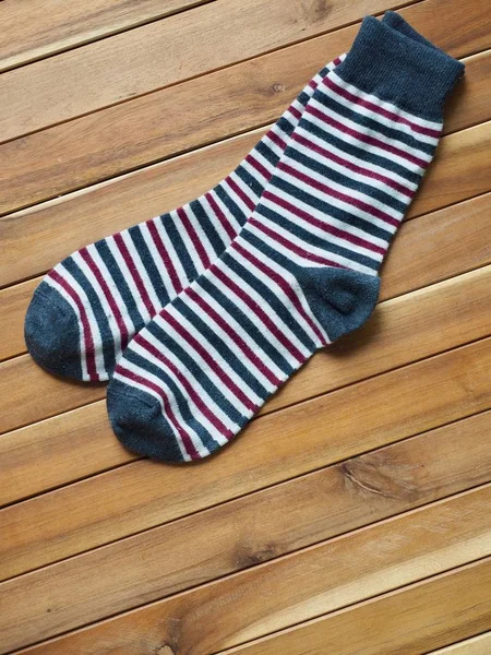Wood board background with striped socks, autumn socks