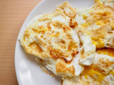 Beyaz bir porselen tabakta kızarmış yumurta.