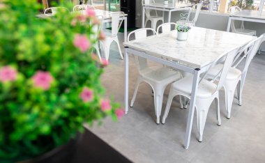 Yemek masası ya da kahve dükkanı, restoranda süslenmiş güzel sahte çiçekler ve sabah güneşi.