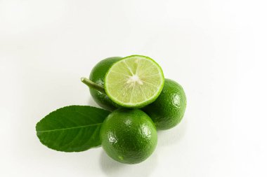 Tayland limonları meyve kümesinin önüne yerleştirilir ve beyaz bir arkaplandan ayrılır.