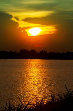 Barajın yanındaki altın günbatımı ışığı güzel doğal manzara, yazın gece manzarası