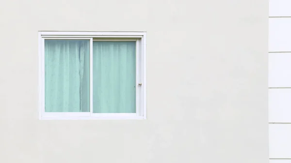 Beyaz çerçeveli pencerelerin beyaz beton duvarlarda pencereleri olan mavi perdeleri var. Kopyalamak için boş alan