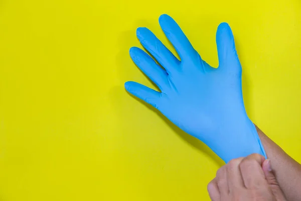 医療用手袋の写真黄色の背景に細菌青を防ぐために — ストック写真