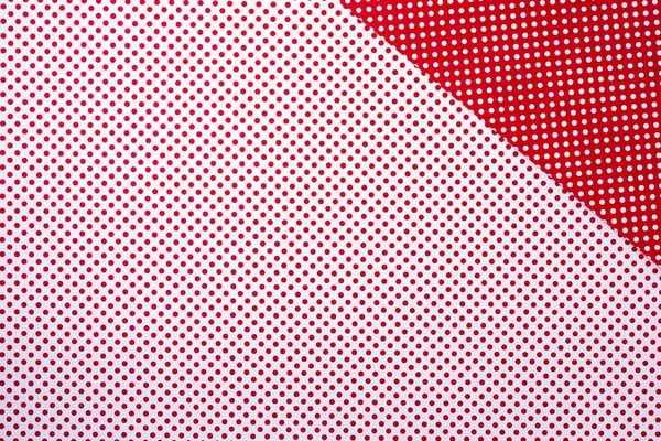 背景の水玉柄と鮮やかな赤と白の表面のトップ ビュー — ストック写真