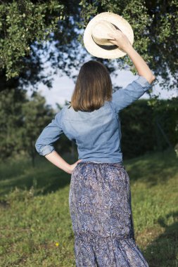 Kadın sırtında bir ormanda başında bir şapka ile poz. sonbaharda.