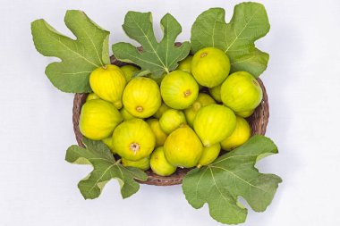 tam taze incir incir yaprakları üzerinde beyaz arka plan ile sepet.