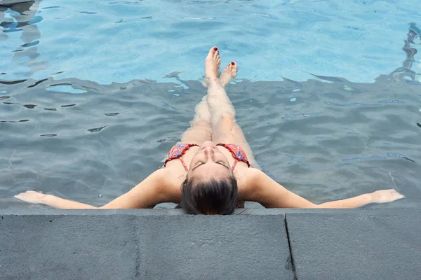 Woman sitting back to back in the pool