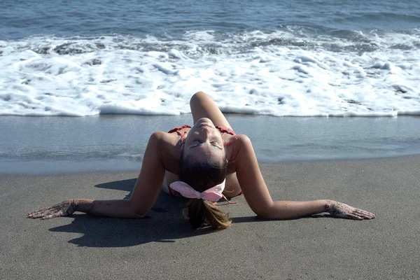 Woman lying on her back the beach sunbathing. — Stock Photo, Image