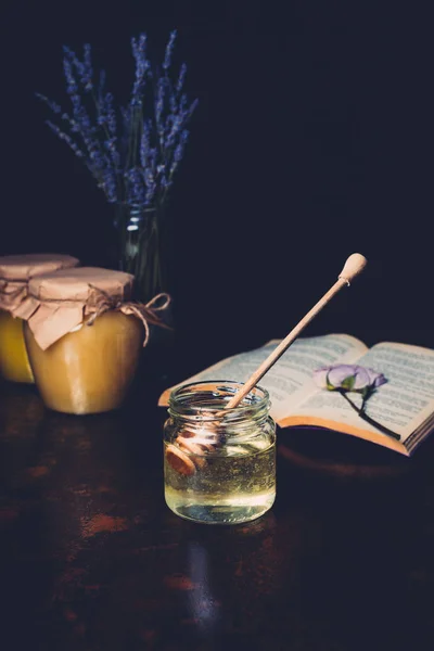Selektivt Fokus Krukker Med Honningpinne Lavendel Svart Bakgrunn – royaltyfritt gratis stockfoto