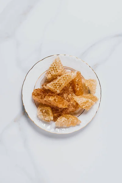 Elevated view of plate with honeycombs on marble table — Stock Photo