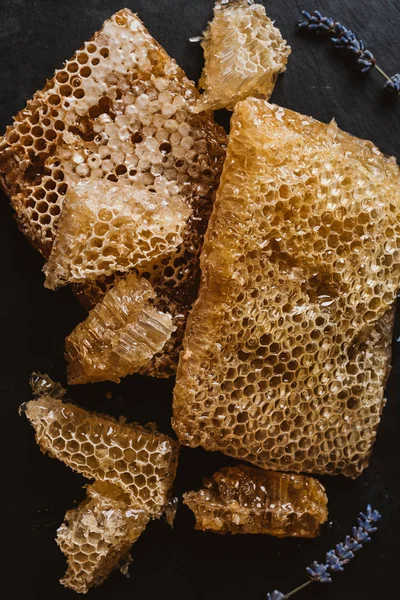 Vue de dessus des nids d'abeilles et des fleurs de lavande sur la table noire — Photo de stock